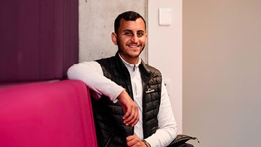 Male student sitting and smiling