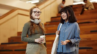 Two female student standing near stairs