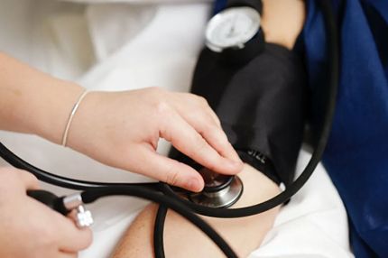 Medical student uses a stethoscope to measure blood pressure