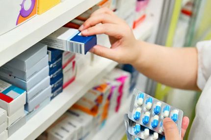 Close-up of a pharmacy shelf with medication boxes and blister packs
