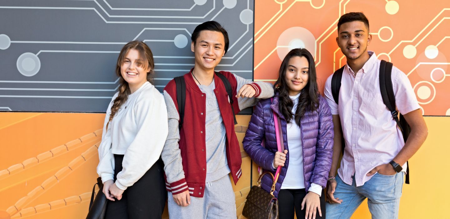 Campus group standing front of colourful wall