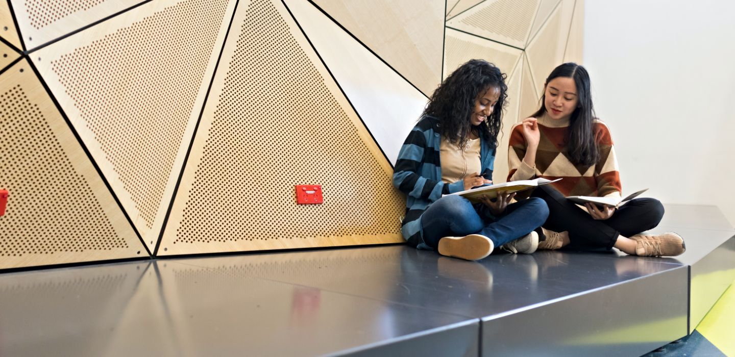 Campus two females reading