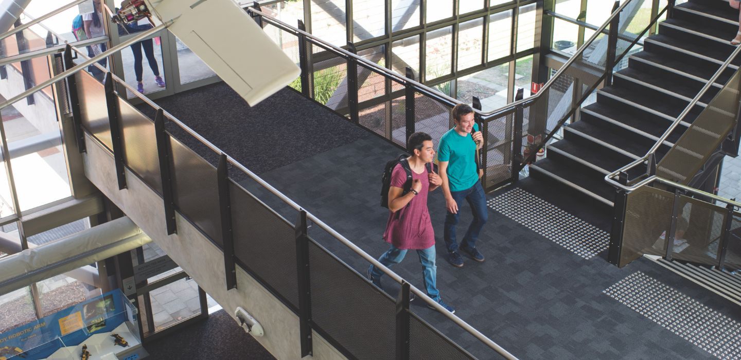 Campus two males walking through corridor