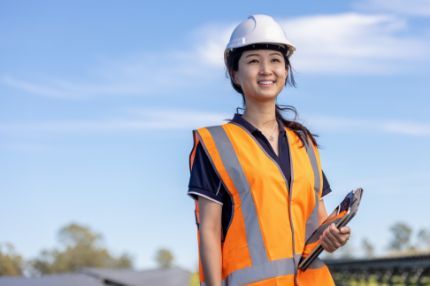 Off campus female holding clipboard at construction site