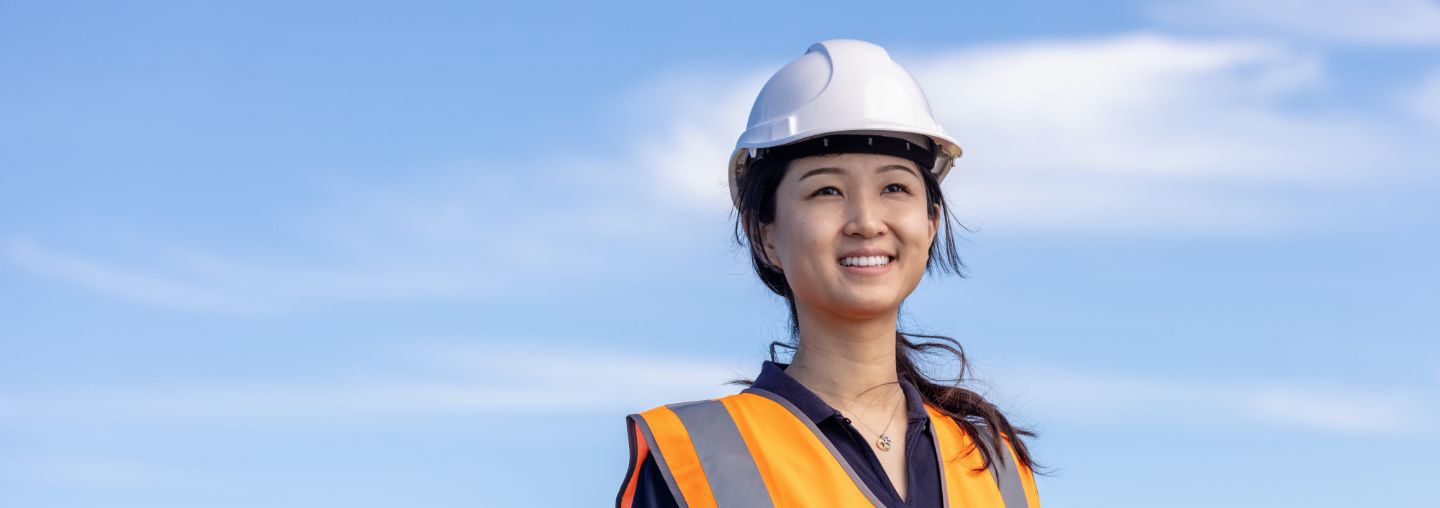 Off campus female holding clipboard at construction site