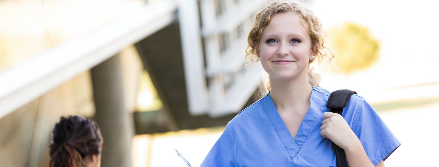 Off campus female nurse walking holding bag