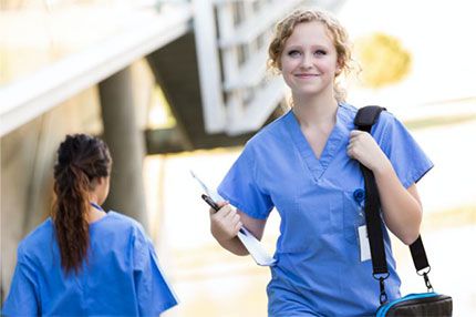 Off campus female nurse walking holding bag