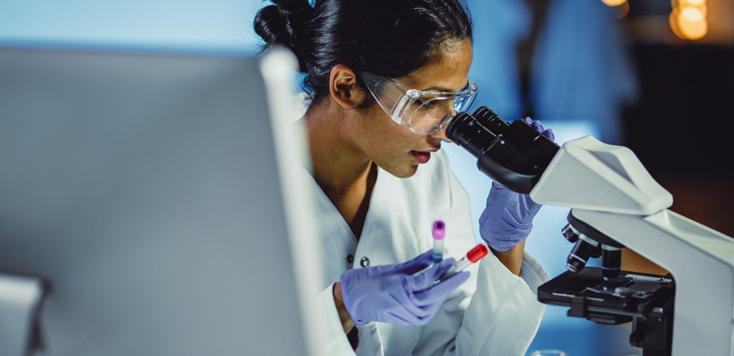 Off campus female scientist looking through scope