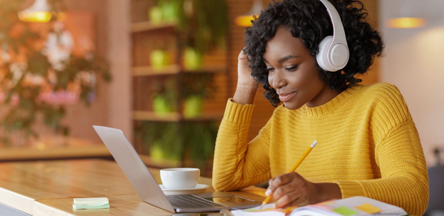 Off campus female wearing headphones studying