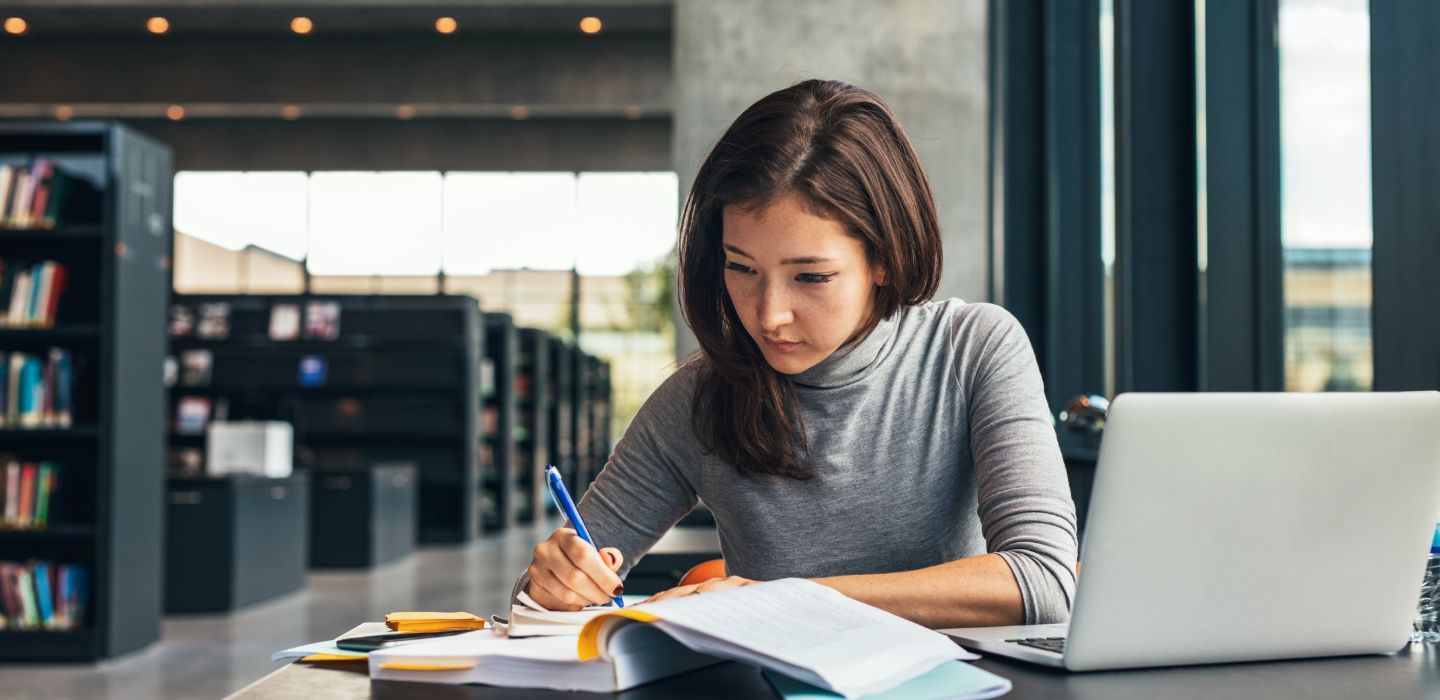 Off campus female writing in book