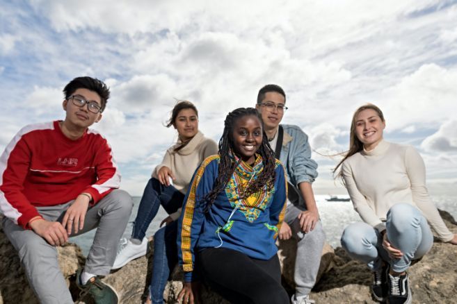 Off campus group sitting on rocks