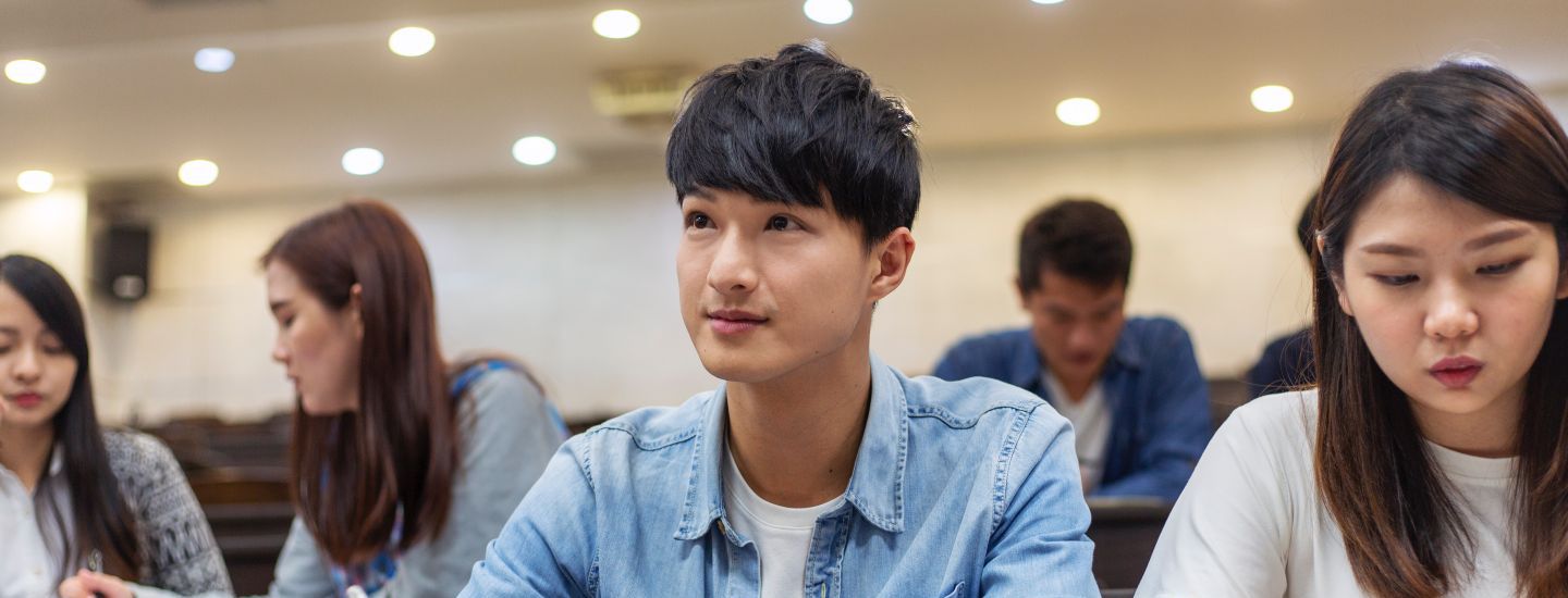 Off campus male and female writing in lecture room